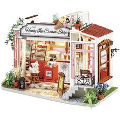 a doll house with furniture and accessories in the front door, including an open window