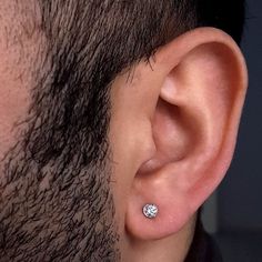 a close up of a man's ear with a small diamond in the middle