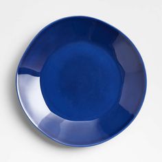 an empty blue plate on a white surface