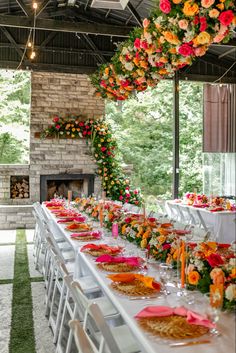 a long table is set up with flowers and place settings for an outdoor wedding reception