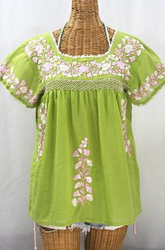 "* Ornate hand embroidery and smocking with hand crocheted trim on the neck and open sleeve hems, available here in MOSS GREEN with PINK MIX embroidery. * Light, gauzy and semi-sheer 100% cotton throughout; wear it billowy and flowing in the bohemian style, or belted for a more fitted look. * Dyed, distressed and embroidered by hand for an authentic, retro-vintage and boho-chic hippie vibe. * Our colorful and ornate floral embroidery patterns are a faithful tribute to the traditional hippie peas Mexican Peasant Blouse, Embroidery Light, Mexican Blouse, Floral Embroidery Patterns, Hippie Vibes, Open Sleeve, Pretty Blouses, Muslin Fabric, The Bohemian