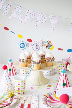 a table topped with cupcakes covered in frosting and sprinkles