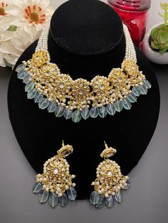 This dabbi kundan set is the perfect mix of traditional and modern set to give a gorgeous look! It comes with matching earrings and is a mix of a beautiful gold finish with pastel blue beads. The Style is inspired by rajasthan and gives a modern and royal look! Kundan Choker Necklace For Reception, Blue Kundan Necklace For Wedding, Blue Kundan Necklace For Reception, Kundan Choker With Gota Work For Wedding, Blue Kundan Necklace With Cutdana For Wedding, Color Azul Pastel, Multicolor Meenakari Gold-plated Necklaces, Luxury Blue Meenakari Necklace, Wedding Jewelry Blue