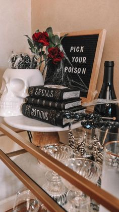 there are many books and wine glasses on the shelf in front of the glassware