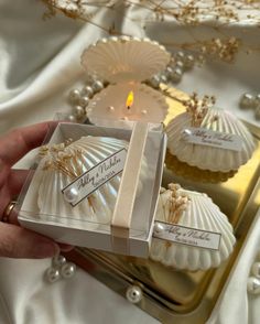 two seashells in a gift box on a table with pearls and other decorations