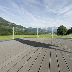 an empty wooden deck with mountains in the background