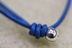 a blue cord with a silver bead on it