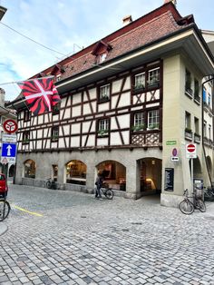 people are riding bicycles in front of an old building on a cobblestone street