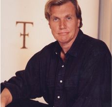 a man sitting in front of a wall with the letter f on it