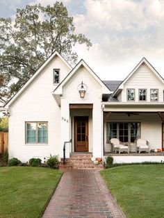 a white house with brick walkway leading to the front door