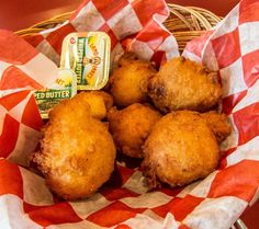 some fried food is in a basket on a red and white checkered table cloth