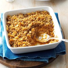 a casserole dish with bread crumbs in it on a wooden board