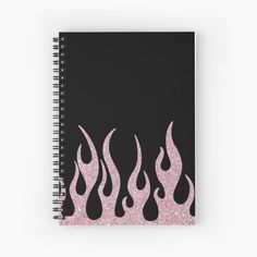 a spiral notebook with pink and black flames on the front, against a black background