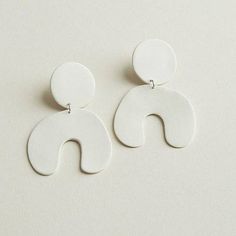 two white earrings with circular shapes on them