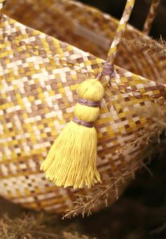 a woven basket with tassels hanging from it