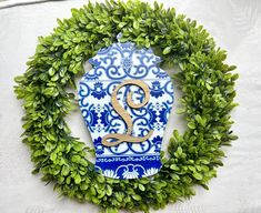 a blue and white vase surrounded by greenery with the number 2 on it's side