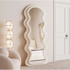 a large white mirror sitting on top of a wall next to a chair and lamp