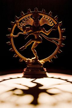 an intricately designed statue on top of a table in the dark with light coming through it