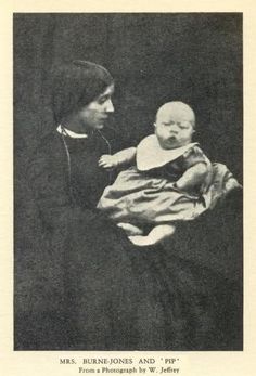 an old black and white photo of a woman holding a baby