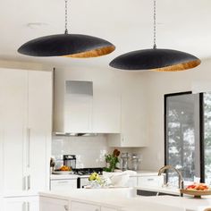 two lights hanging from the ceiling in a kitchen