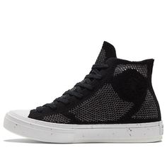 a black and white high top sneaker with an eye patch on the upper part