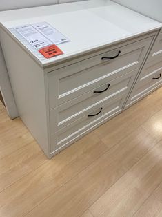 a white filing cabinet with three drawers and a label on the top that says,