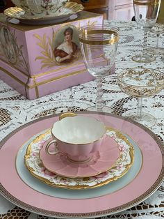 a pink and gold china set on top of a table