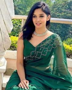 a woman in a green dress sitting on a bench