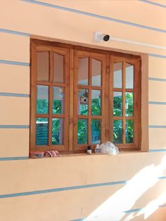 an open window on the side of a house with blue and white striped wallpaper