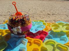 an ice cream sundae on the beach with candy and candies in it is ready to be eaten