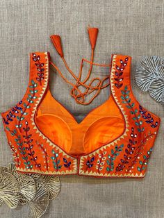 Stunning orange multicolor thread and mirror work sleeveless blouse, Buy designer blouse in USA from Pure Elegance. Disclaimer: The actual product may vary slightly from the image. These are custom orders, hence expect slight variation in color, placement of the motif or buta. ESTIMATED DELIVERYBecause this is a custom order, it would take about 4 weeks from the date of purchase. RETURN POLICY: This product is a custom order and cannot be returned or exchanged. Banarasi Sari, Designer Saree Blouse, Blouse Works, Mirror Work Blouse, Blouse Designer, Corset Blouse, Saree Style, Readymade Saree, Embroidered Saree