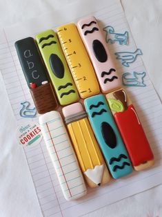 there are many different shaped cookies in the shape of pencils on top of a sheet of paper