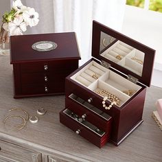 two wooden jewelry boxes sitting on top of a table