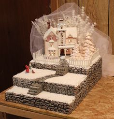 a cake made to look like a house with snow on the ground and trees around it