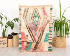 a colorful rug is on the floor next to some potted plants and other decorative items