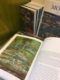 the book is opened to show an image of a bridge and water lilies on it