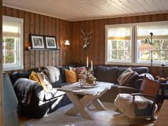 a living room filled with furniture and wooden walls