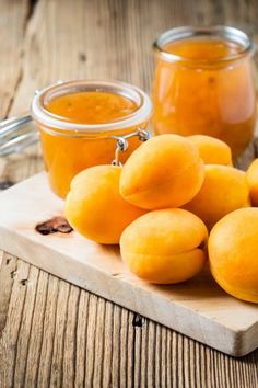 apricots on a cutting board next to jars of orange marmalade sauce