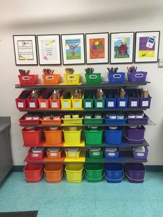 there are many different colored bins on the shelf in this classroom room with pictures above them