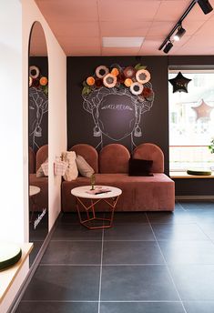 a living room filled with furniture next to a wall mounted chalkboard on the wall