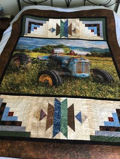 a bed with a quilt on top of it and an old truck in the background