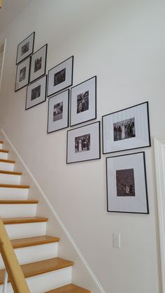 there are pictures on the wall above the stairs