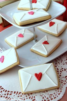 cookies decorated with envelopes and hearts on a plate