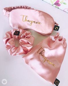 two pink satin hair ties with personalized names on them