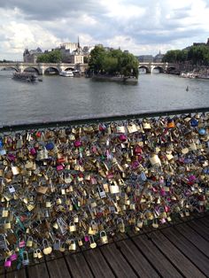 padlocks are attached to the fence along the river