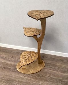 a three tiered wooden stand with leaves on it