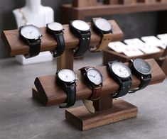 several watches are displayed on wooden stands