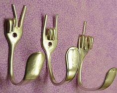 three metal hooks on a purple wall