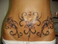 a woman's stomach with tattoos on it and an image of flowers in the middle