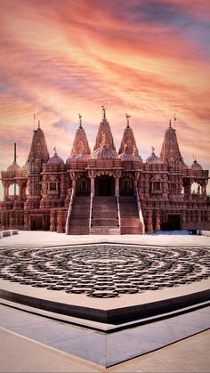 an intricately designed building with many spires and pillars in front of a sunset sky